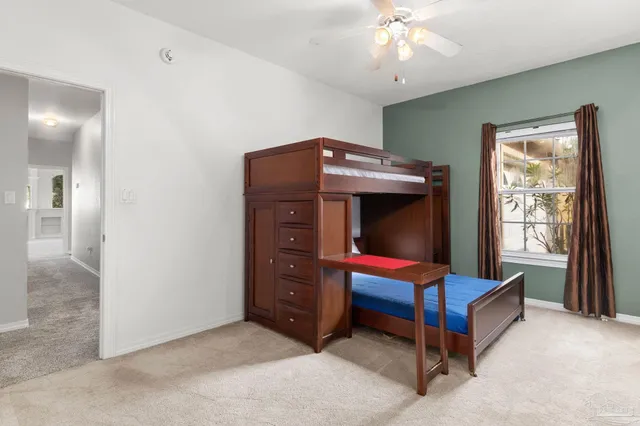an empty room with chandelier fan and windows