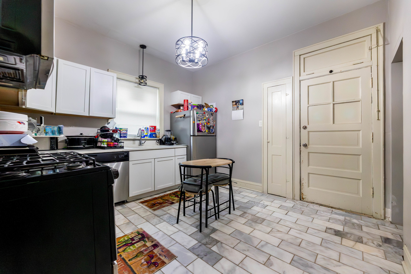 12258 South Normal Avenue Chicago, IL 60628 - Photo 5 of 21 a kitchen with stainless steel appliances granite countertop a stove top oven a sink a dining table and chairs with wooden floor