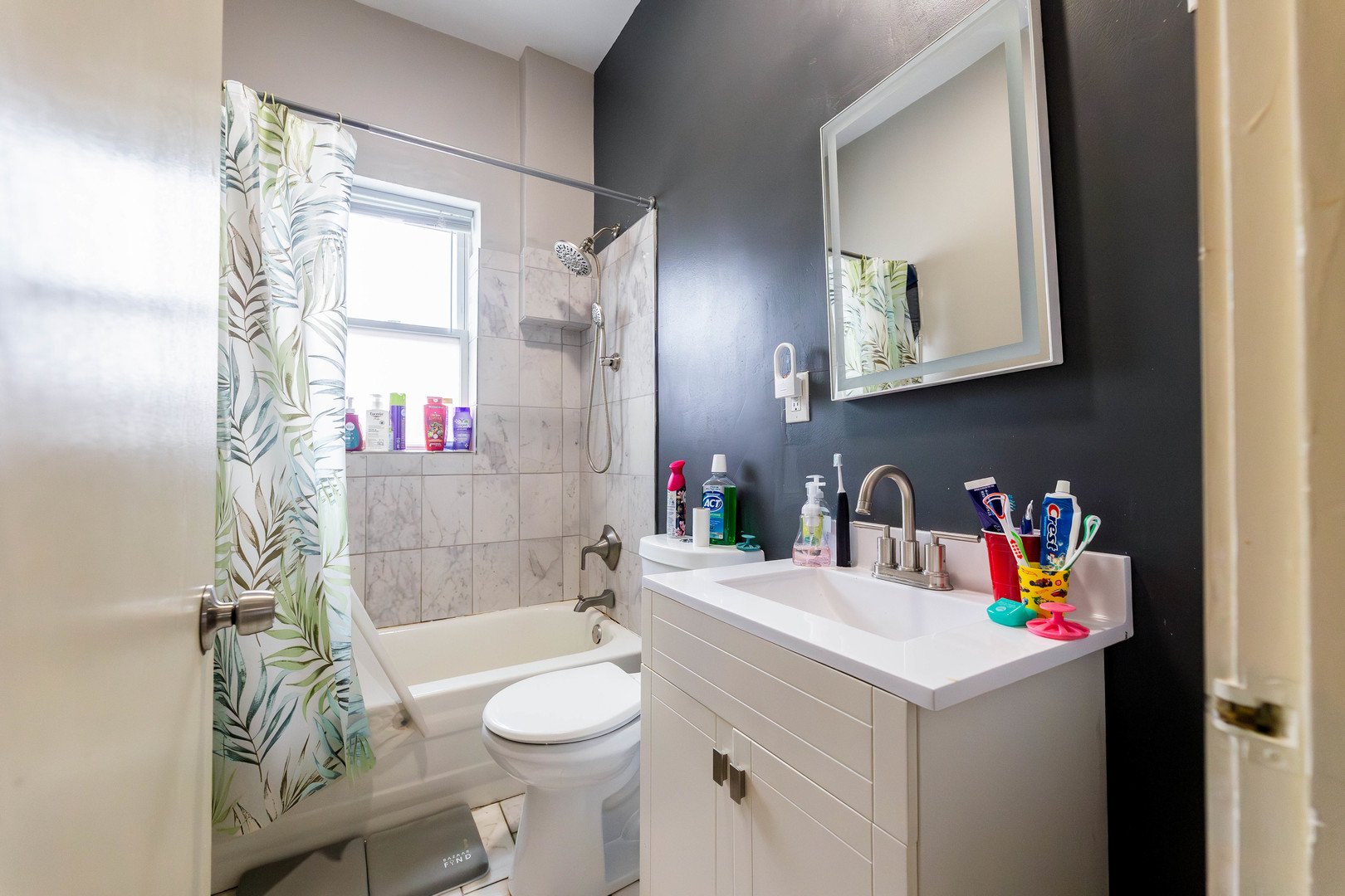 12258 South Normal Avenue Chicago, IL 60628 - Photo 9 of 21 a bathroom with a sink a toilet and shower curtain