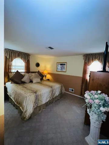 a bedroom with a bed potted plant and dresser