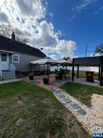 a view of a house with backyard and sitting area