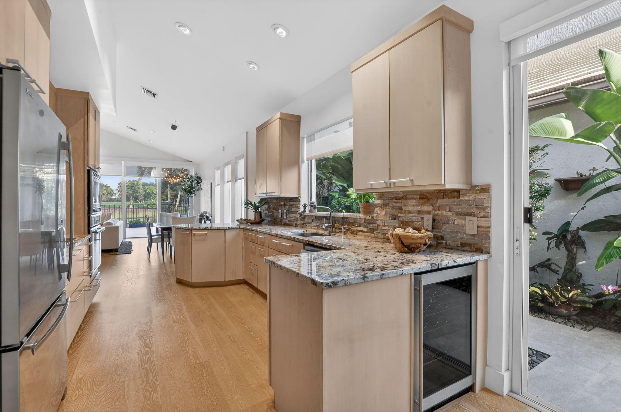 2051 Northwest 56th Street Boca Raton, FL 33496 - Photo 18 of 58 a kitchen with a large window appliances and cabinets