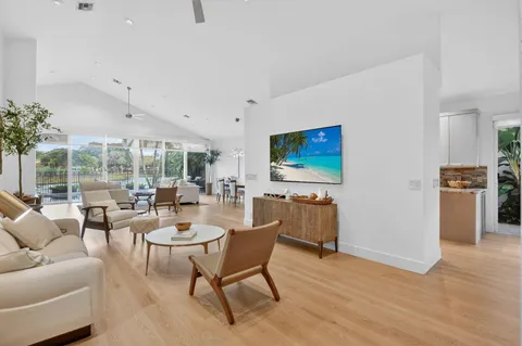 a living room with furniture a flat screen tv and a large window