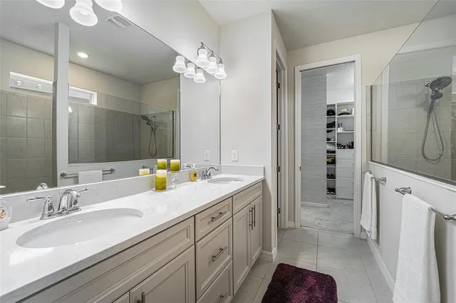 a spacious bathroom with double vanity a mirror and double