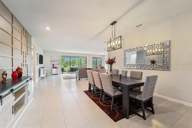 a view of a dining room and livingroom with furniture wooden floor a chandelier