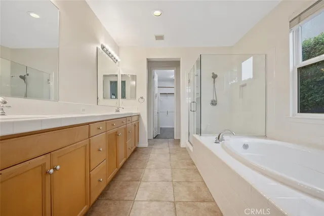 a spacious bathroom with a tub sink shower and mirror