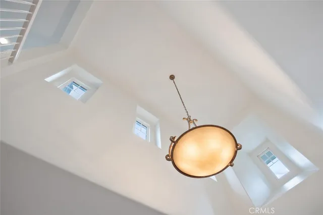 a view of a room with a chandelier fan and wooden floor