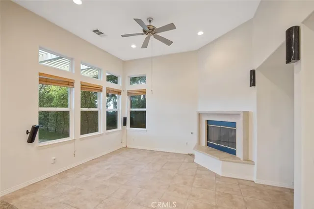 a view of an empty room with a window and a kitchen