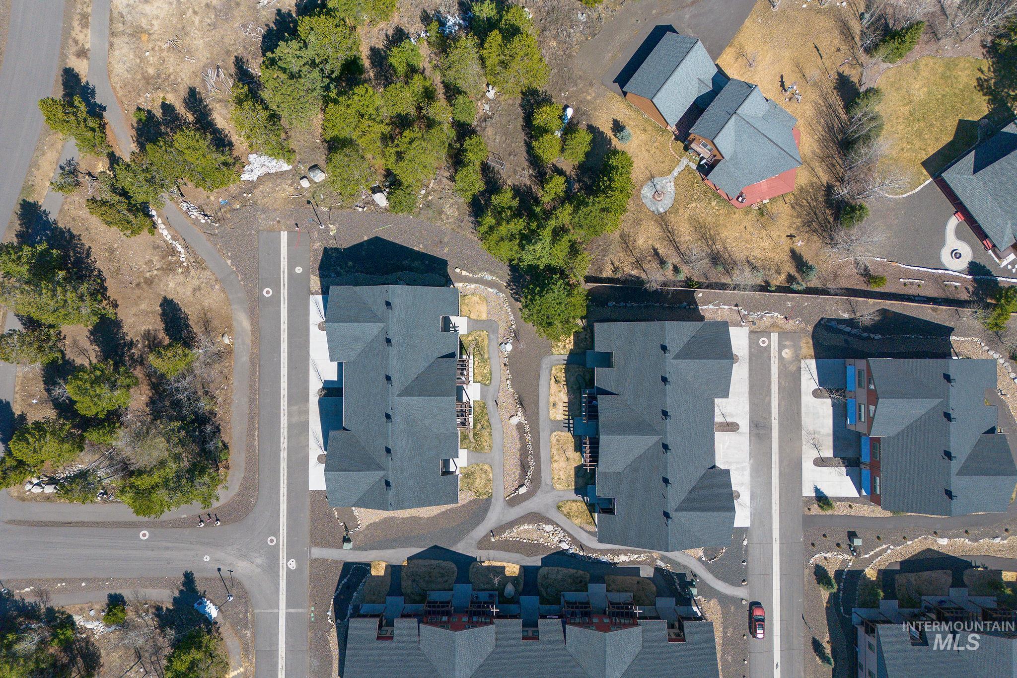 311 Broken Ridge Way McCall, ID 83638 - Photo 3 of 44 Aerial perspective showcasing multiple residential structures with dark shingled roofs and paved driveways