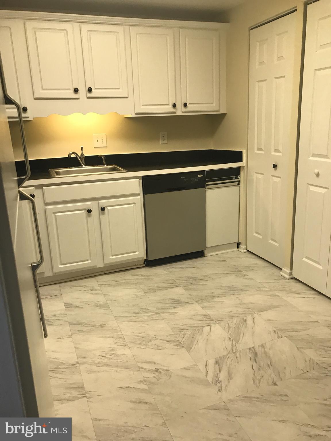 a kitchen with granite countertop white cabinets and stainless steel appliances