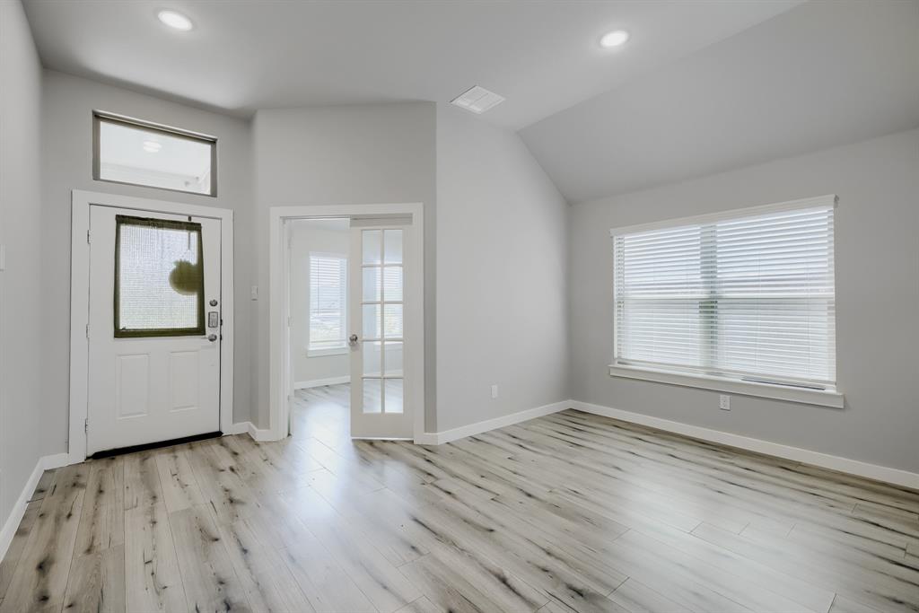 114 Mandarin Street Forney, TX 75126 - Photo 2 of 11 Spacious room featuring wood-finish flooring, a large window with blinds, recessed ceiling lighting, and a vaulted ceiling
