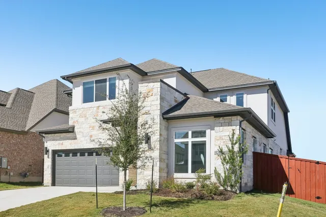 a front view of a house with a garden and yard