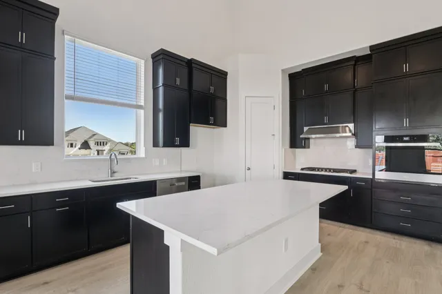 a spacious bathroom with a granite countertop sink a mirror and shower