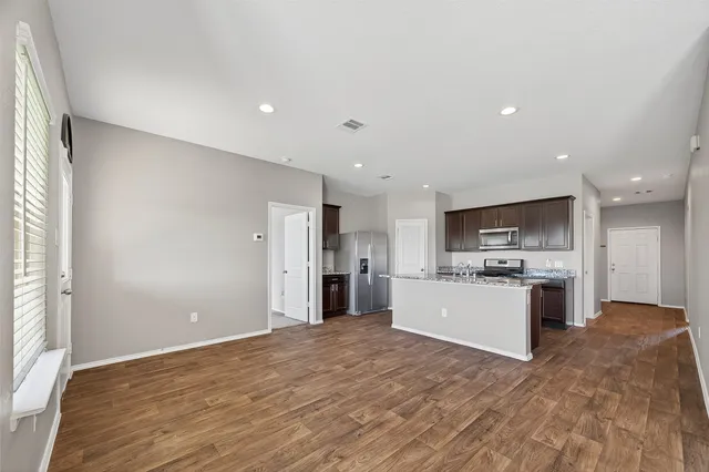 a kitchen with a refrigerator and a stove top oven
