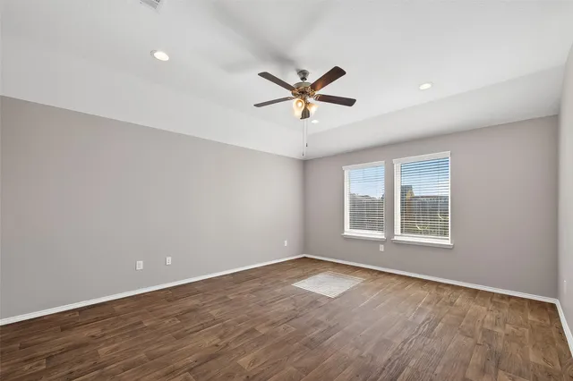 an empty room with a window and a ceiling fan
