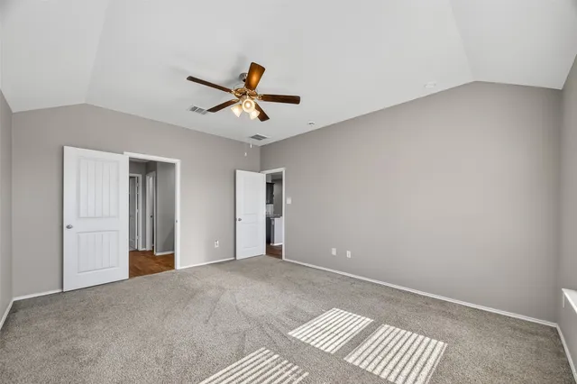 an empty room with a ceiling fan and a fan