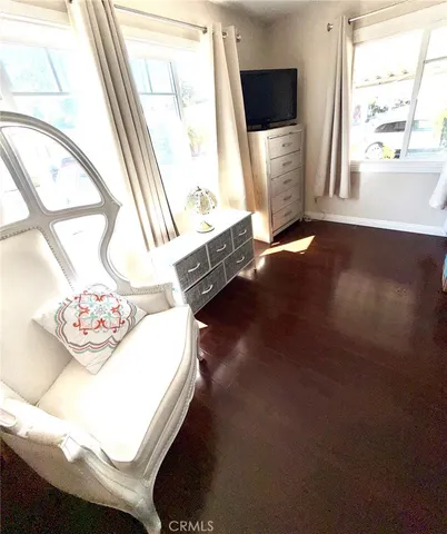 a living room with a bed furniture and a flat screen tv