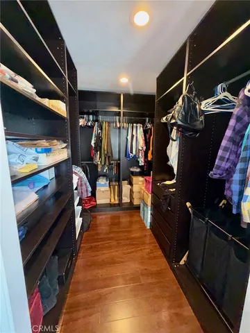 a view of walk in closet with clothes and shoes