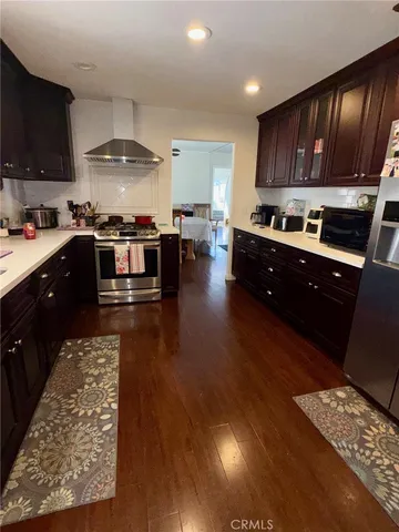 a kitchen with stainless steel appliances granite countertop a refrigerator a stove and a wooden floors