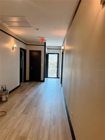 a view of a hallway with wooden floor and closet
