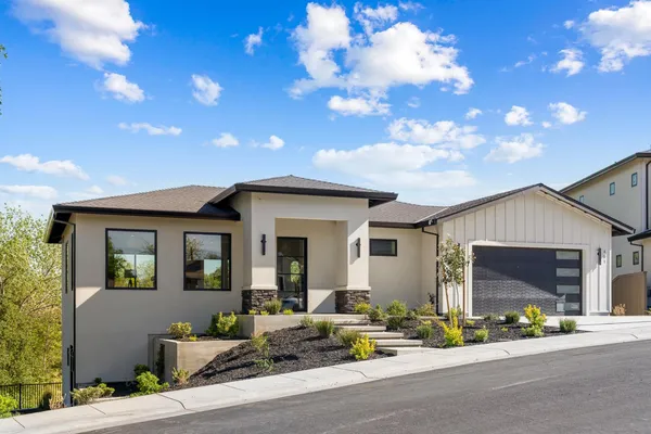 a front view of a house with a garden and patio