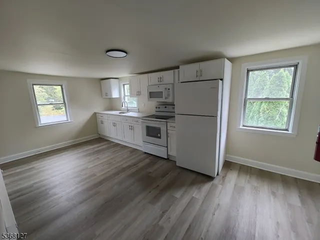 a kitchen with wooden floors and refrigerator