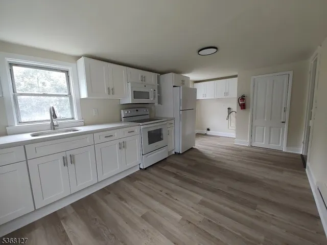 a kitchen with stainless steel appliances a sink cabinets and wooden floor
