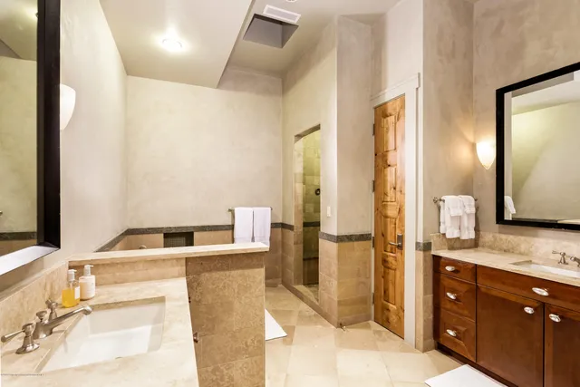 a bathroom with a tub sink and mirror