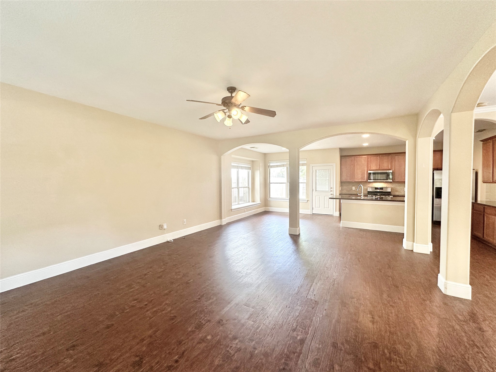 43 Panterra Way Spring, TX 77382 - Photo 4 of 17 a view of an empty room with wooden floor and a kitchen