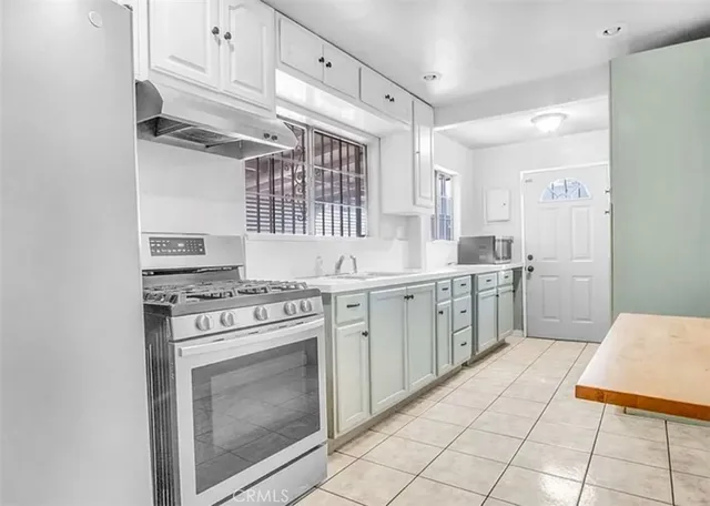a kitchen with a stove sink and cabinets