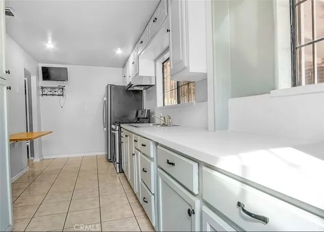 a kitchen with stainless steel appliances a sink and a refrigerator