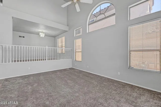 an empty room with fan and windows