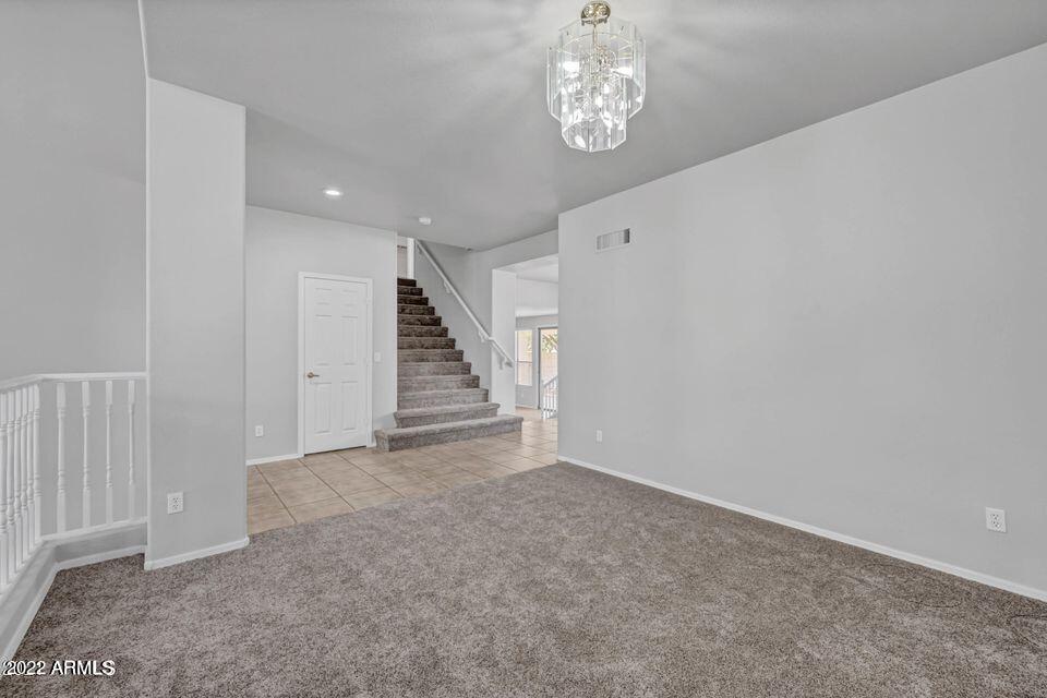 6410 West Hackamore Drive Phoenix, AZ 85083 - Photo 14 of 50 an empty room with a chandelier