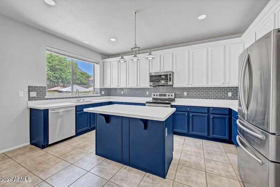 6410 West Hackamore Drive Phoenix, AZ 85083 - Photo 15 of 50 a kitchen with kitchen island granite countertop a stove sink and cabinets
