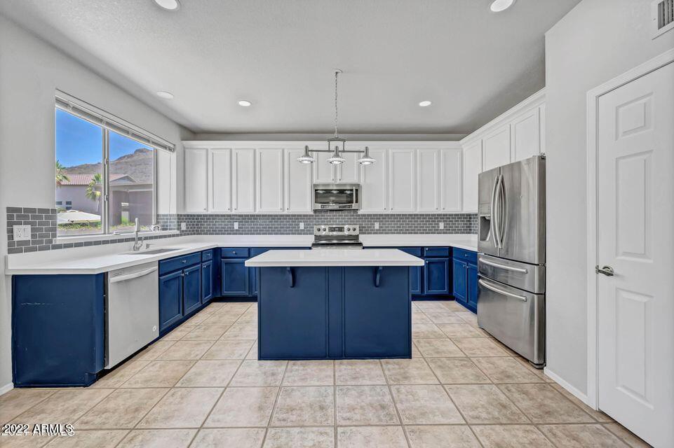 6410 West Hackamore Drive Phoenix, AZ 85083 - Photo 16 of 50 a kitchen with kitchen island granite countertop a sink cabinets and refrigerator