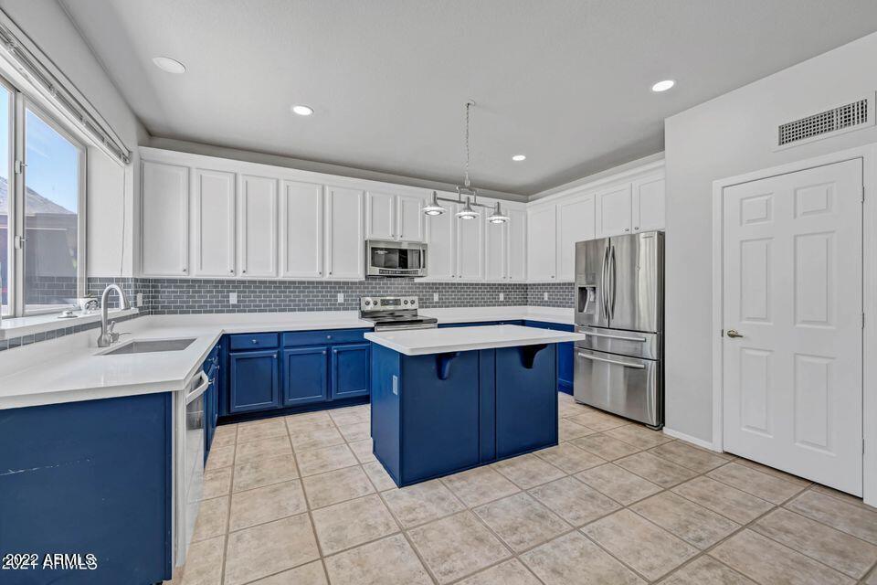 6410 West Hackamore Drive Phoenix, AZ 85083 - Photo 17 of 50 a kitchen with stainless steel appliances granite countertop a sink counter space cabinets and a refrigerator