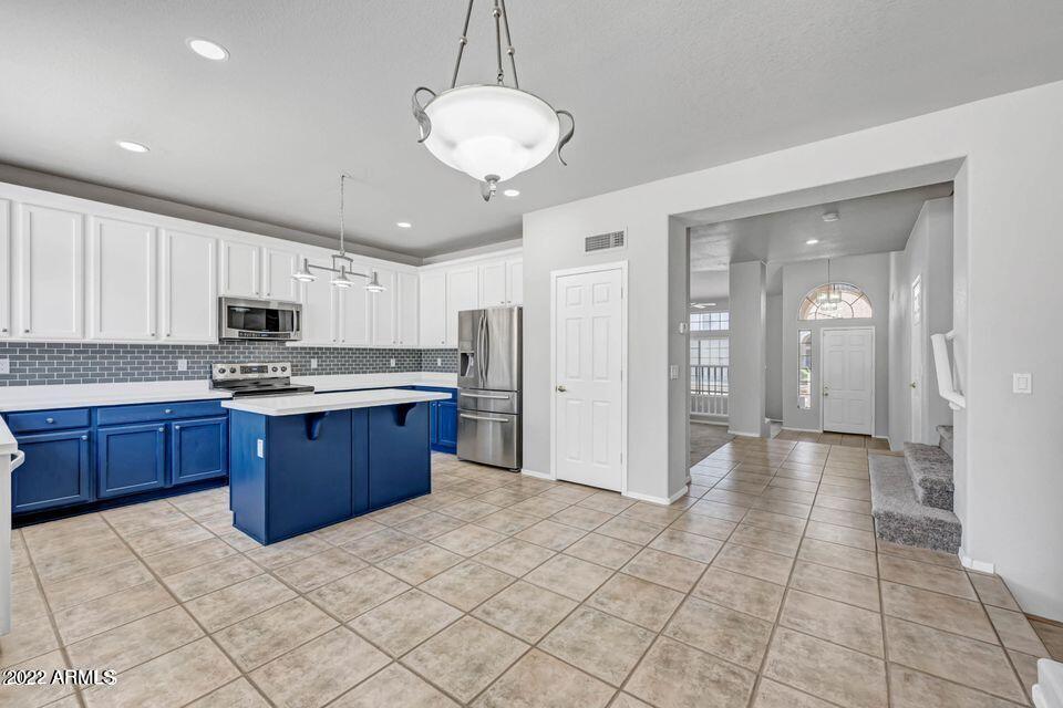 6410 West Hackamore Drive Phoenix, AZ 85083 - Photo 23 of 50 a kitchen with stainless steel appliances granite countertop a refrigerator and a stove top oven