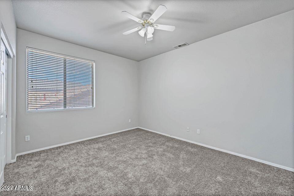 6410 West Hackamore Drive Phoenix, AZ 85083 - Photo 37 of 50 an empty room with a window and a ceiling fan