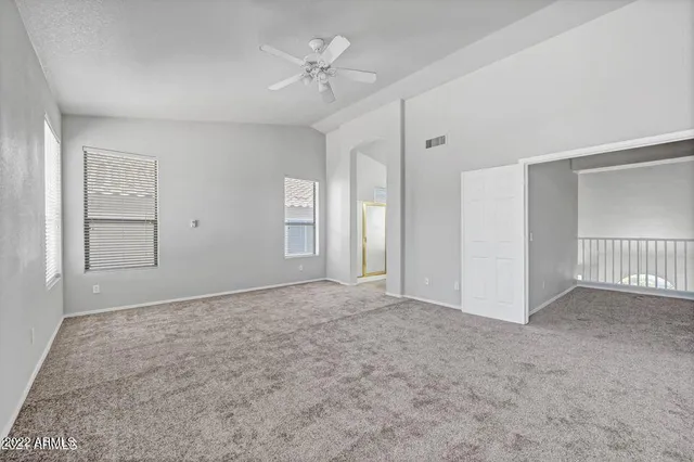 an empty room with fan and entrance