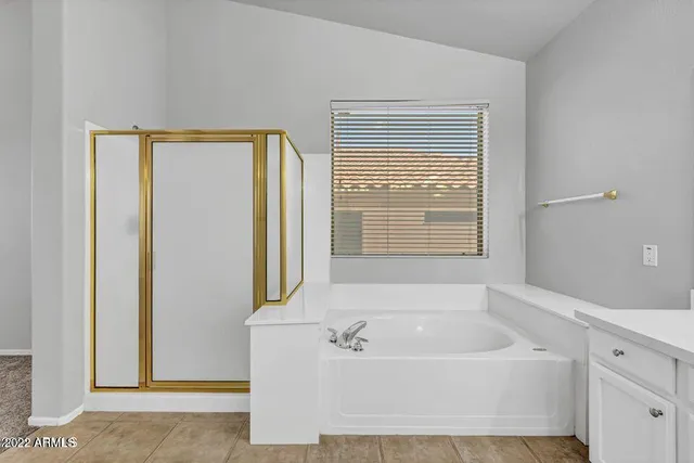 a bathroom with a sink double vanity granite tub shower and a mirror