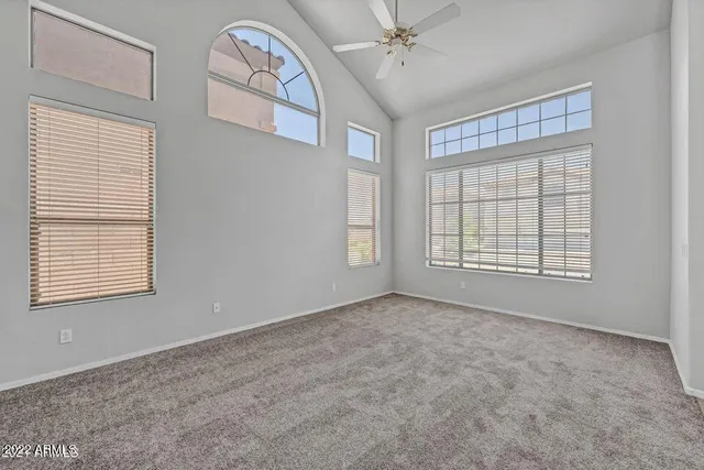 an empty room with windows and fan