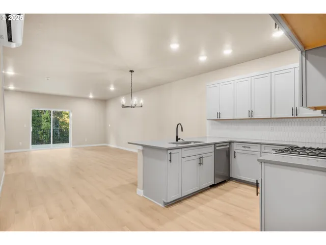 a kitchen with stainless steel appliances granite countertop a sink stove and cabinets