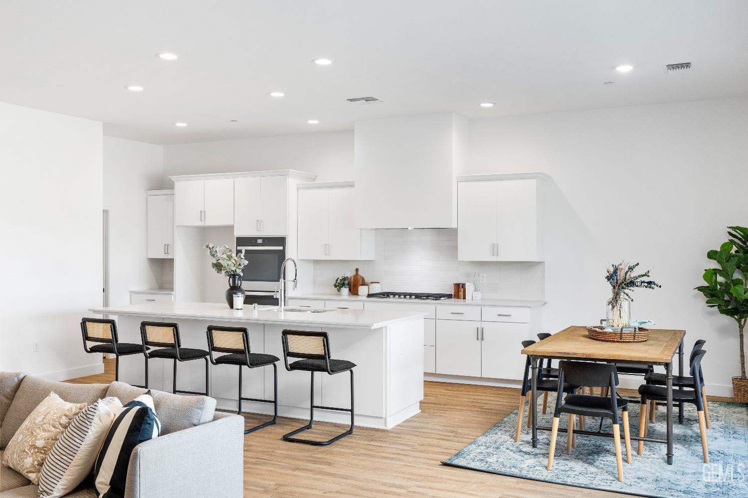 Undisclosed Address Bakersfield, CA 93314 - Photo 25 of 36 a kitchen with a dining table chairs and white cabinets