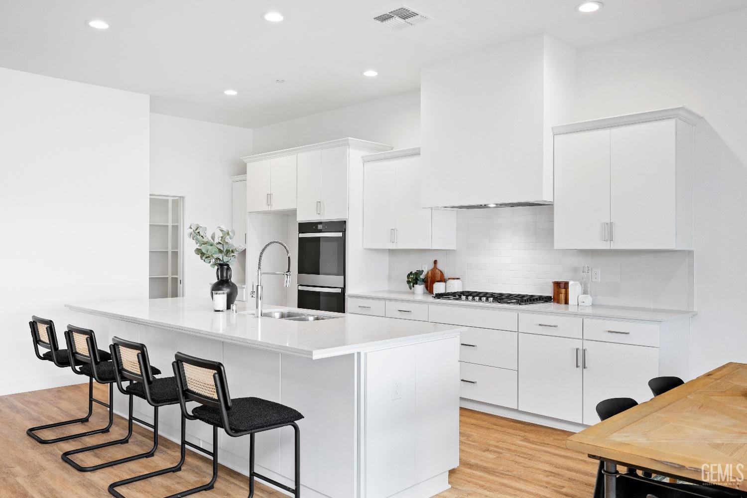 Undisclosed Address Bakersfield, CA 93314 - Photo 26 of 36 a kitchen with stainless steel appliances kitchen island granite countertop a table chairs sink and cabinets
