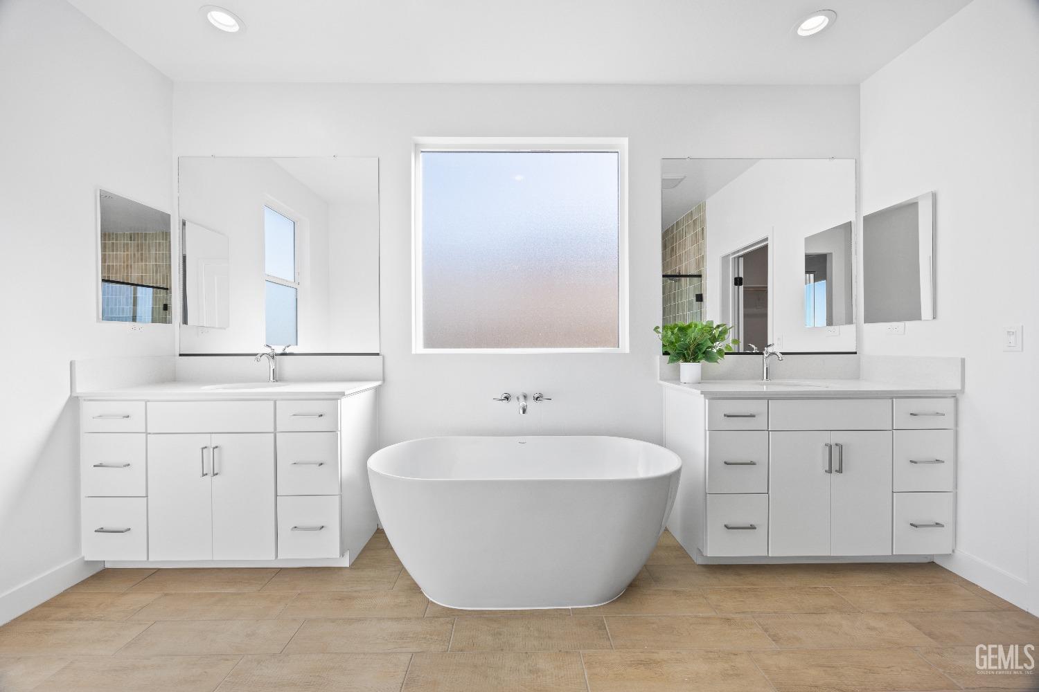 Undisclosed Address Bakersfield, CA 93314 - Photo 4 of 36 a spacious bathroom with a double vanity sink a mirror and a bathtub