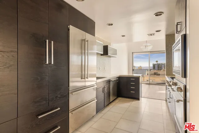 a large kitchen with a stove a refrigerator and a sink
