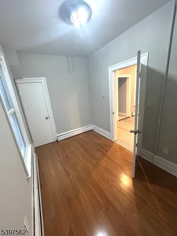 an empty room with wooden floor and entrance