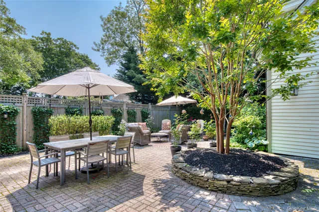 a view of a patio with a table and chairs under an umbrella