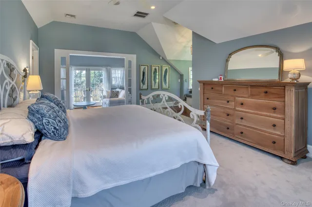 a spacious bedroom with a bed and a dresser