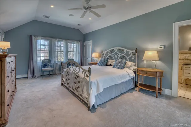 a spacious bedroom with a bed and a chandelier